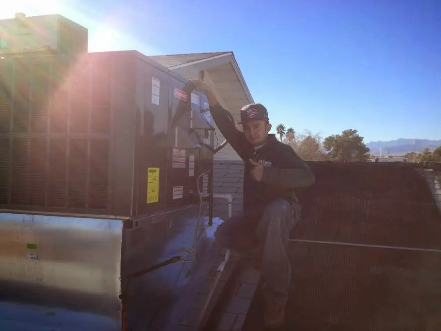 HVAC technician performing AC Tune-Up on a rooftop unit in Lewisboro